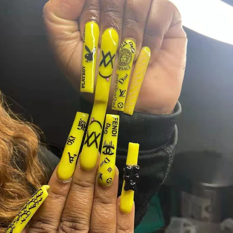Pop Art Extravaganza Extra Long Square Press on Nail Set in Vibrant Yellow with Bold Black Designer Inspired Patterns and Accents